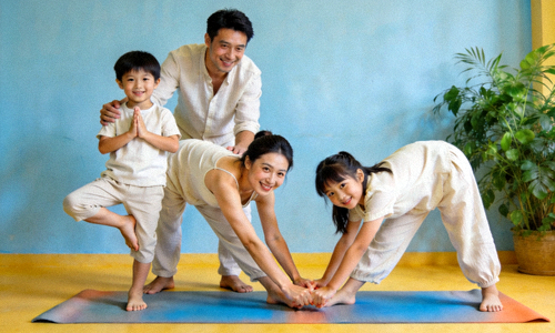 家庭亲子瑜伽 - 父母与孩子一起在垫子上进行亲子瑜伽练习